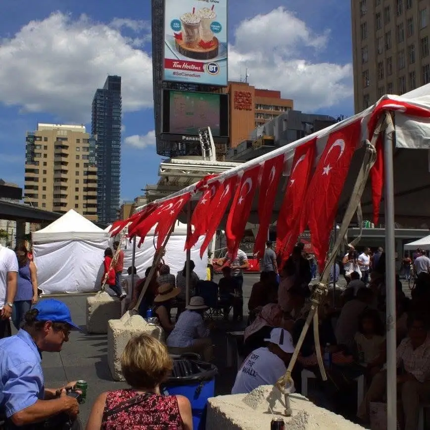 Red Turkish bunting along the market tents, the square’s towers and billboards behind.