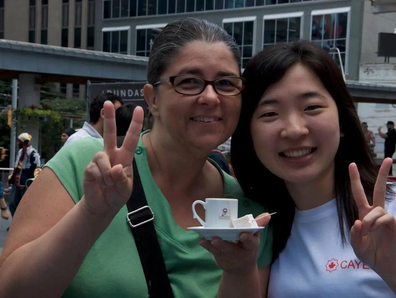 Two visitors hold up cups of Turkish coffee and make the peace sign.