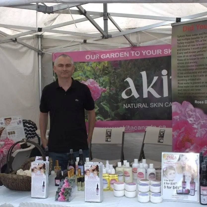 A natural skin care stand with bottles and jars laid out on a table.